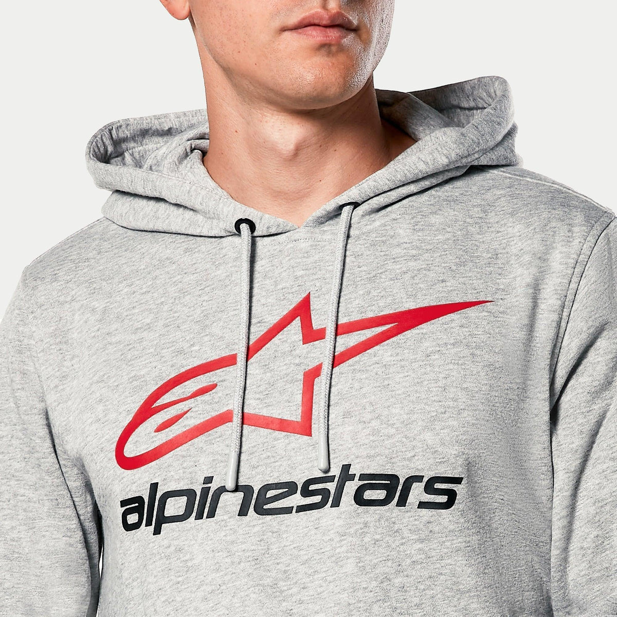 Alpinestars Always V3 Hoodie, grigio melangiato, primo piano del petto con logo a stella rosso e scritta Alpinestars nera, cappuccio foderato in jersey con cordini grigi, abbigliamento casual motorsport