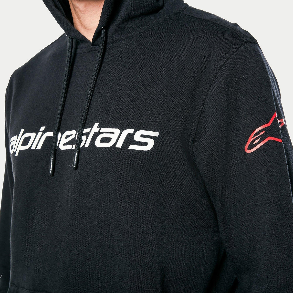 Alpinestars Linear Wordmark V3 Hoodie, nero, scritta Alpinestars bianca sul petto e logo Ageless rosso sulla manica, felpa pullover sportswear casual con cappuccio e cordino