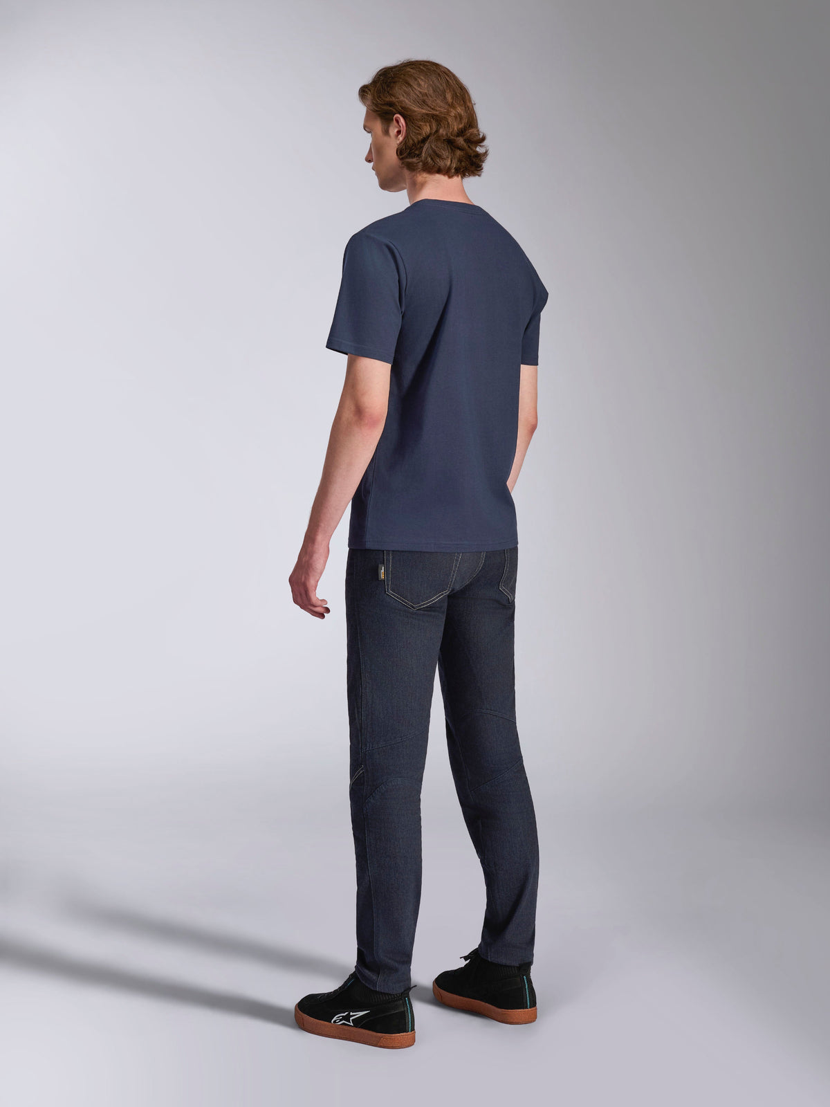Alpinestars Ageless 2.0 CSF Tee, maglietta a maniche corte, blu navy, vista posteriore, indossata con jeans in denim scuro e sneakers nere, streetwear casual da motorsport