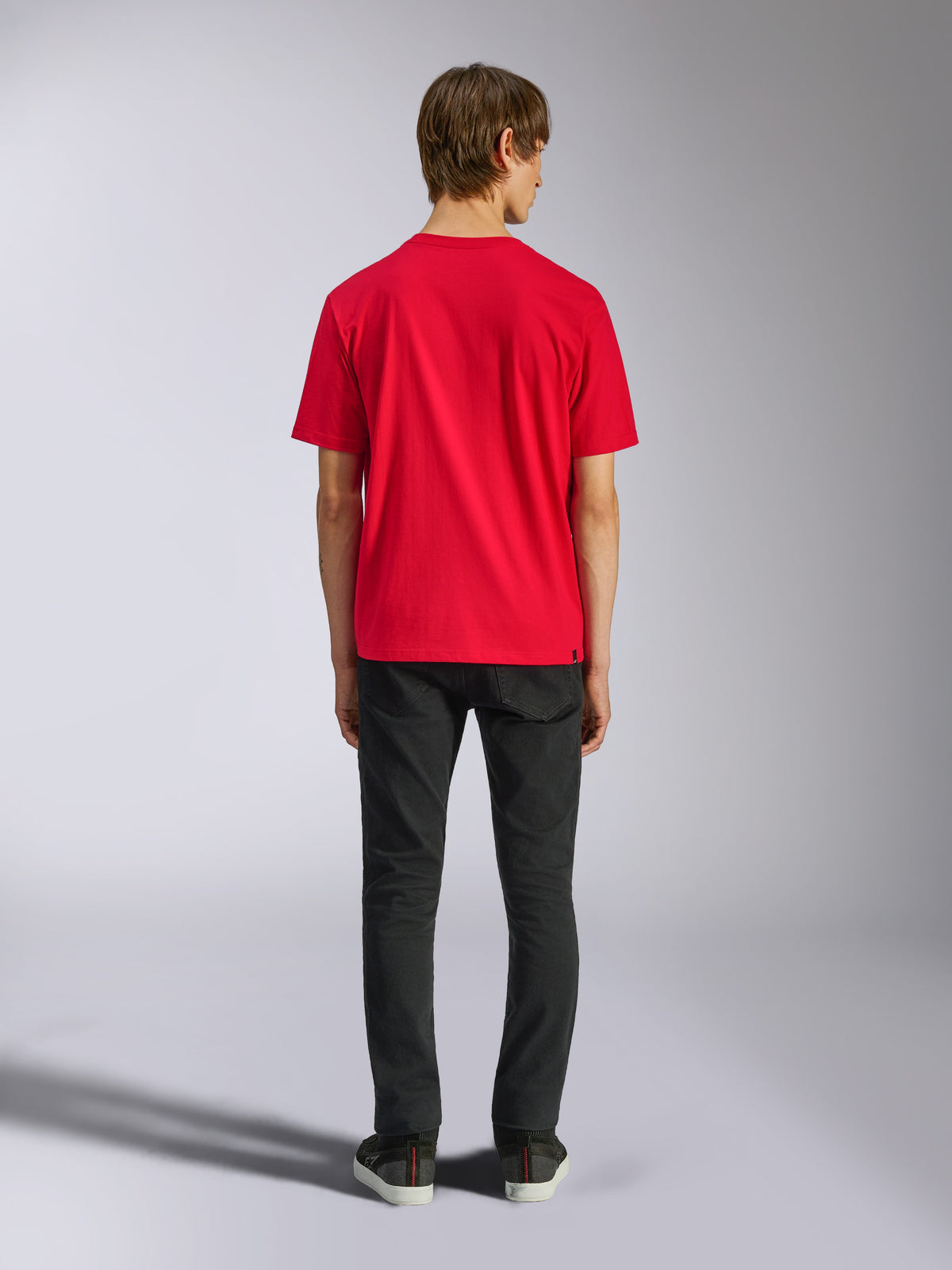 Alpinestars Ageless Shadow CSF Tee, maglietta a maniche corte, rosso, vista posteriore su modello abbinata a pantaloni neri, streetwear casual motorsport
