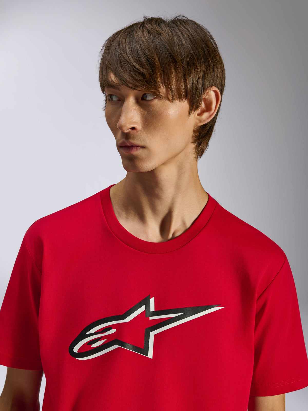 Alpinestars Ageless Shadow CSF Tee, t-shirt a maniche corte, rosso, logo frontale Ageless a stella con effetto ombra bianco e nero, indossata da un modello, design casual ispirato al motorsport