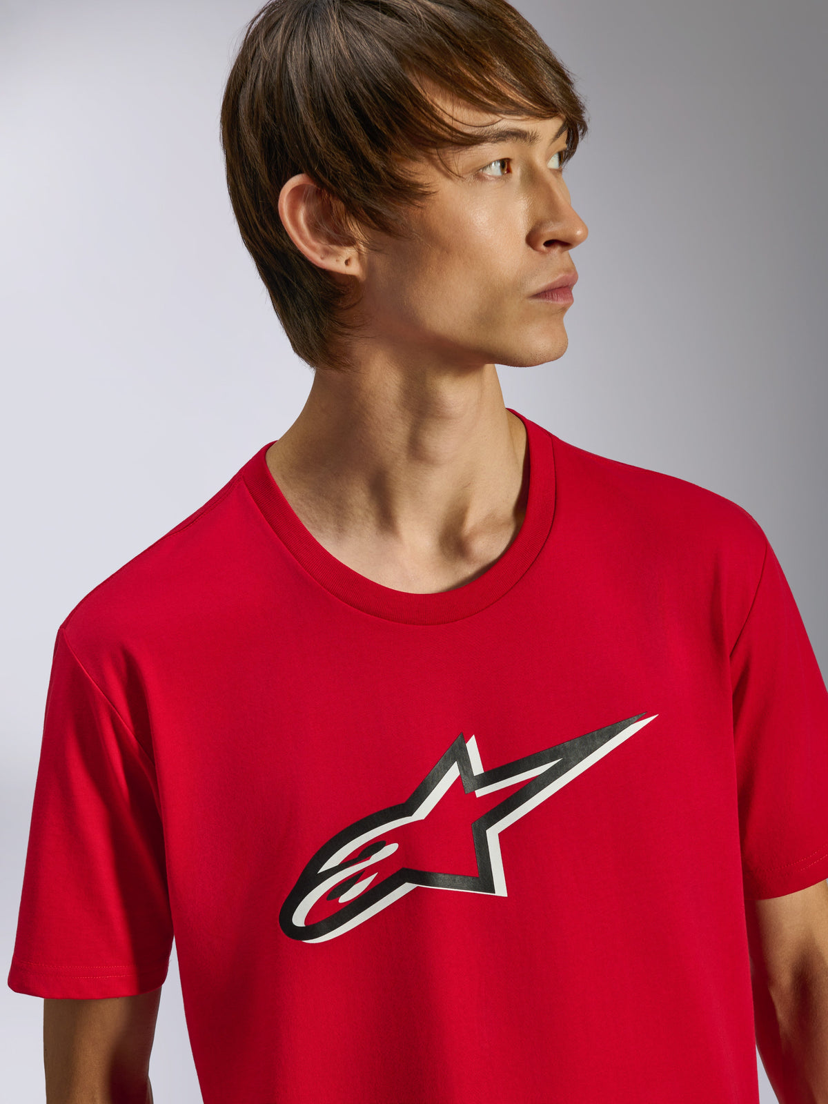 Alpinestars Ageless Shadow CSF Tee, maglietta a maniche corte, rossa, con logo Ageless frontale con effetto ombra bianco e nero, indossata da un modello, streetwear casual motorsport