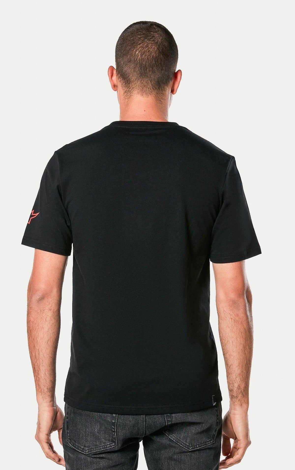 Alpinestars Linear Wordmark 2.0 CSF Tee, nero, vista posteriore di una persona che indossa la t-shirt a maniche corte, con logo Ageless rosso sulla manica, abbigliamento casual motorsport streetwear