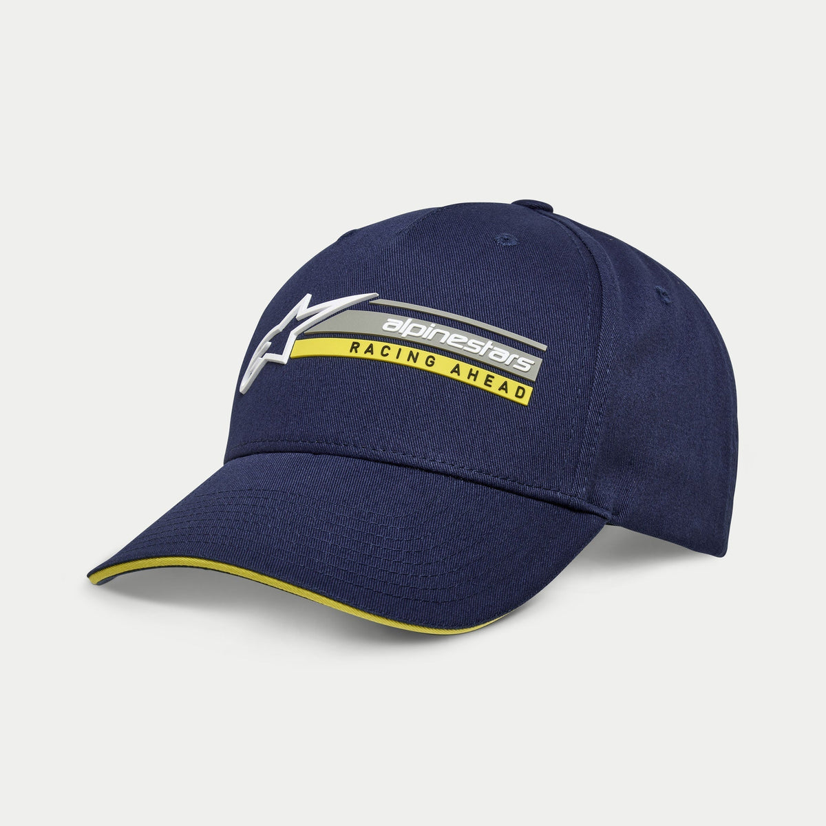 Alpinestars Par Hat, cappellino snapback blu navy, visiera curva con bordo sandwich giallo, logo ricamato in 3D con grafica 'Racing Ahead', copricapo casual ispirato al motorsport