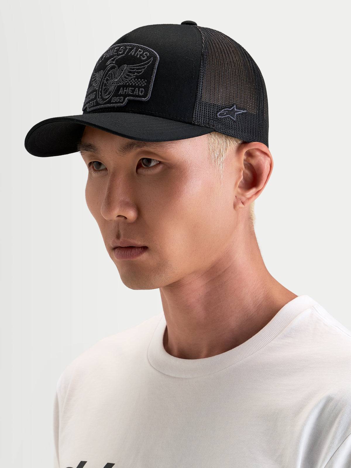 Alpinestars Cappello Heritage Patch, cappellino trucker sportswear casual, nero e grigio, con visiera curva e corona strutturata con patch logo ricamata sul davanti, indossato da un modello