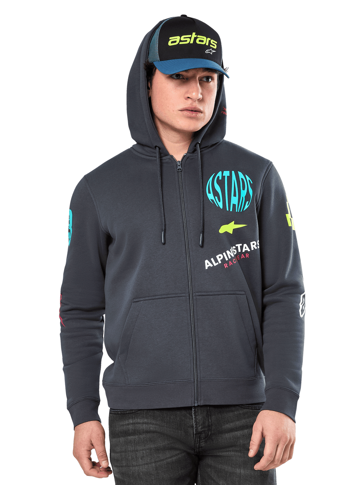 Felpa con cappuccio Alpinestars Variegate, felpa in pile con zip frontale, grigio antracite con grafiche logo multicolore su petto e maniche, indossata da un modello con cappellino coordinato, streetwear casual con tasche a marsupio e cerniera a tutta lunghezza