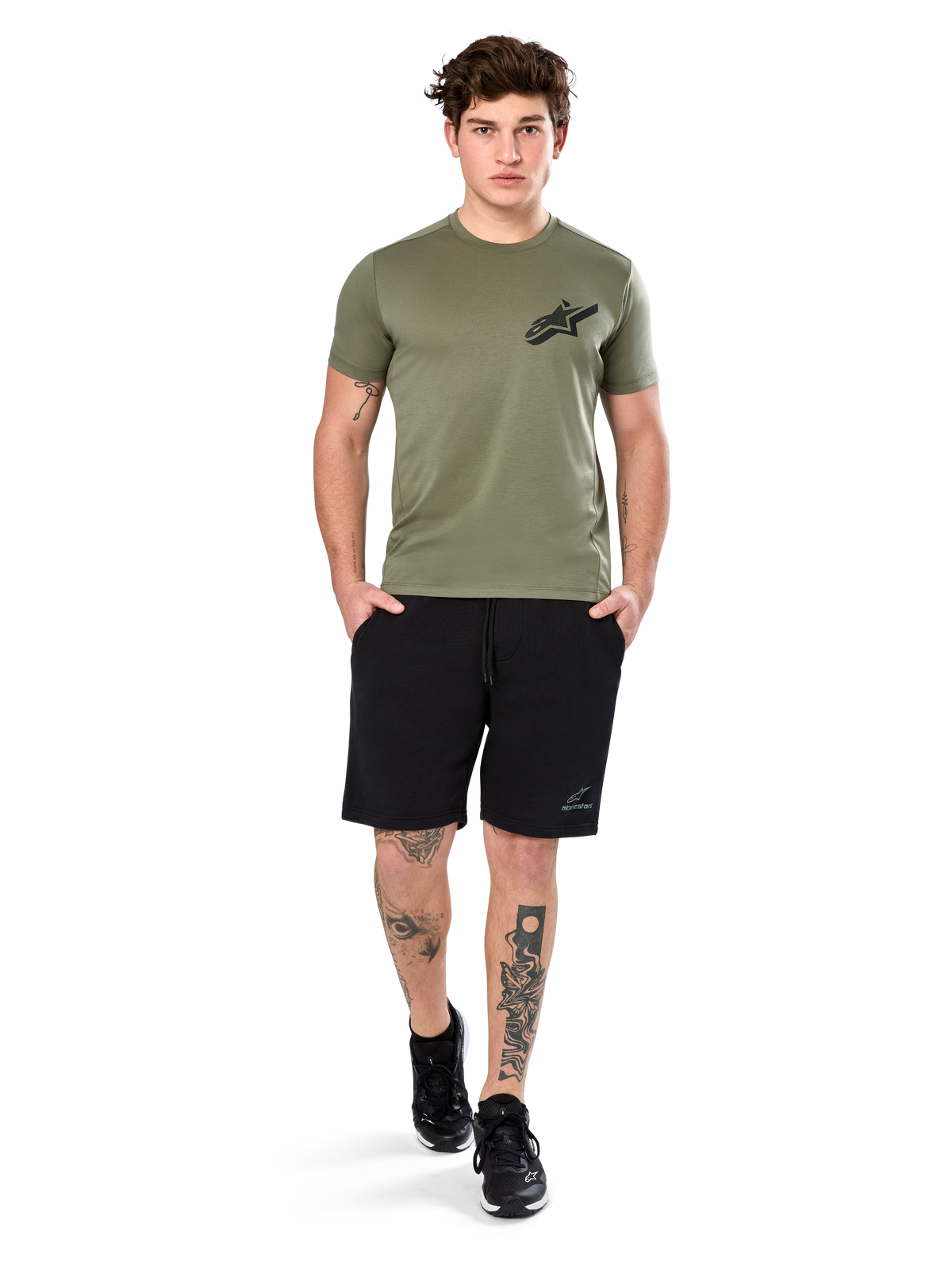 Alpinestars Attrition Performance Tee, t-shirt a maniche corte, verde chiaro, con logo Astars nero sul petto, indossata con pantaloncini sportivi neri e sneakers nere, scatto lifestyle casual performance sportswear