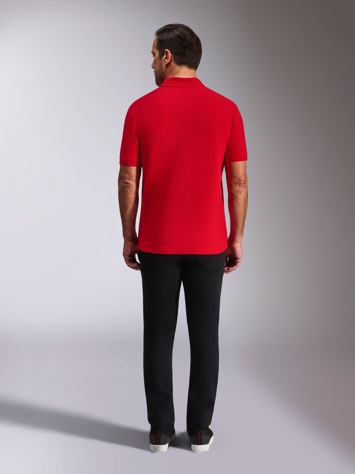Polo Alpinestars Endeavor Classic, polo in piqué rossa, vista posteriore, indossata con pantaloni neri, streetwear casual per il motorsport con colletto e polsini a coste