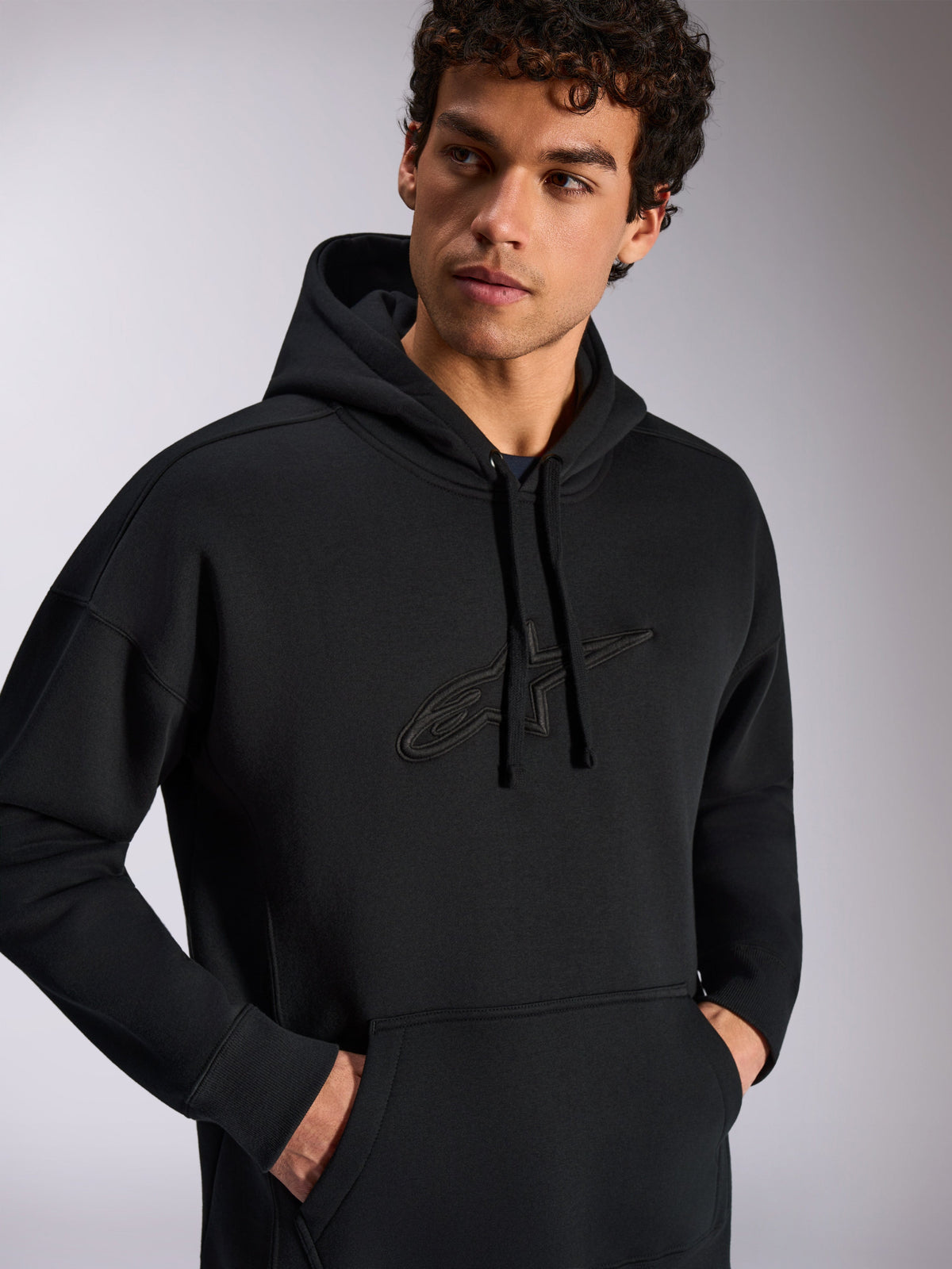 Felpa con cappuccio Alpinestars Emergent Oversized, abbigliamento casual streetwear, nero con logo a stella ricamato in 3D tono su tono, cappuccio con coulisse, tasca a marsupio, vestibilità ampia oversize