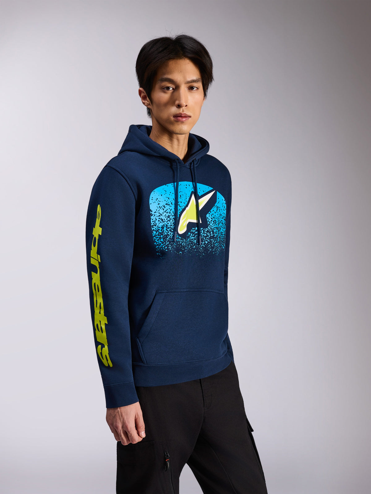 Alpinestars Obsessed Hoodie, felpa con cappuccio blu navy, modello pullover con logo Astars frontale con sfumatura MX azzurra e scritta gialla sulla manica, abbigliamento streetwear casual motorsport