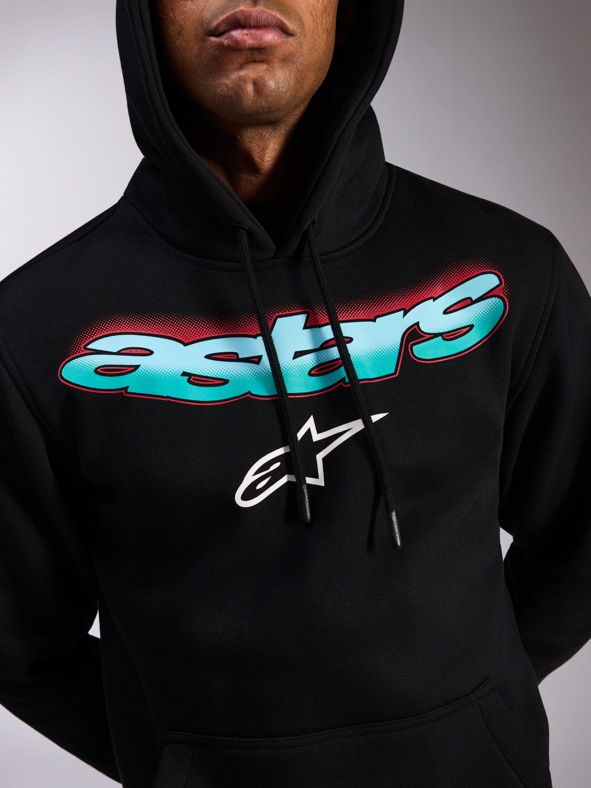 Alpinestars Ellipsoid Hoodie, felpa pullover nera, scritta Astars con gradiente di colore verde acqua e blu e accenti halftone rossi, logo a stella bianco, cappuccio con cordino, streetwear casual ispirato al motorsport