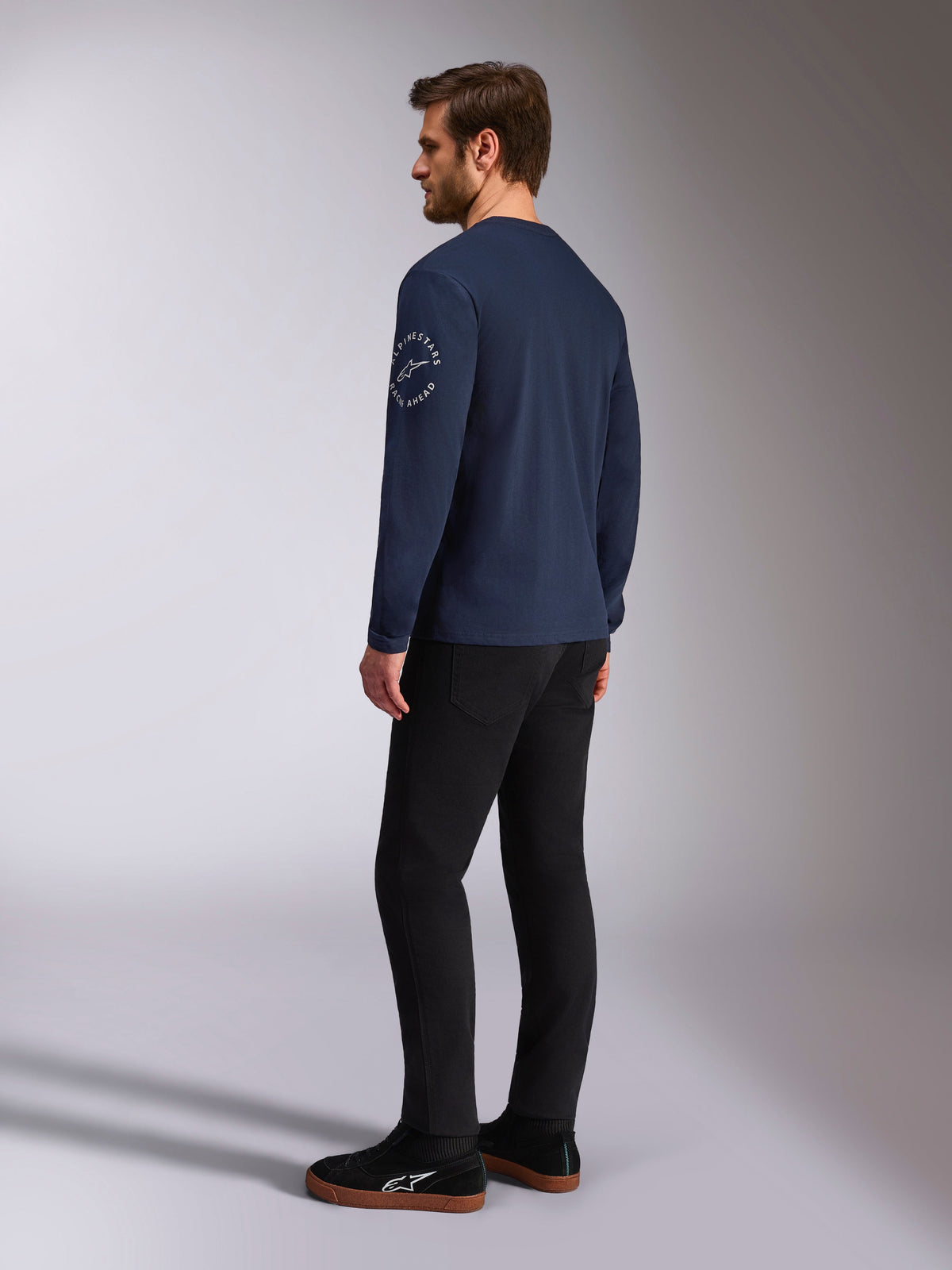 Alpinestars Mandatory CSF Tee - Maniche Lunghe, blu navy, logo circolare bianco sulla manica, vista posteriore, indossata con pantaloni neri e sneakers nere, abbigliamento casual motorsport streetwear