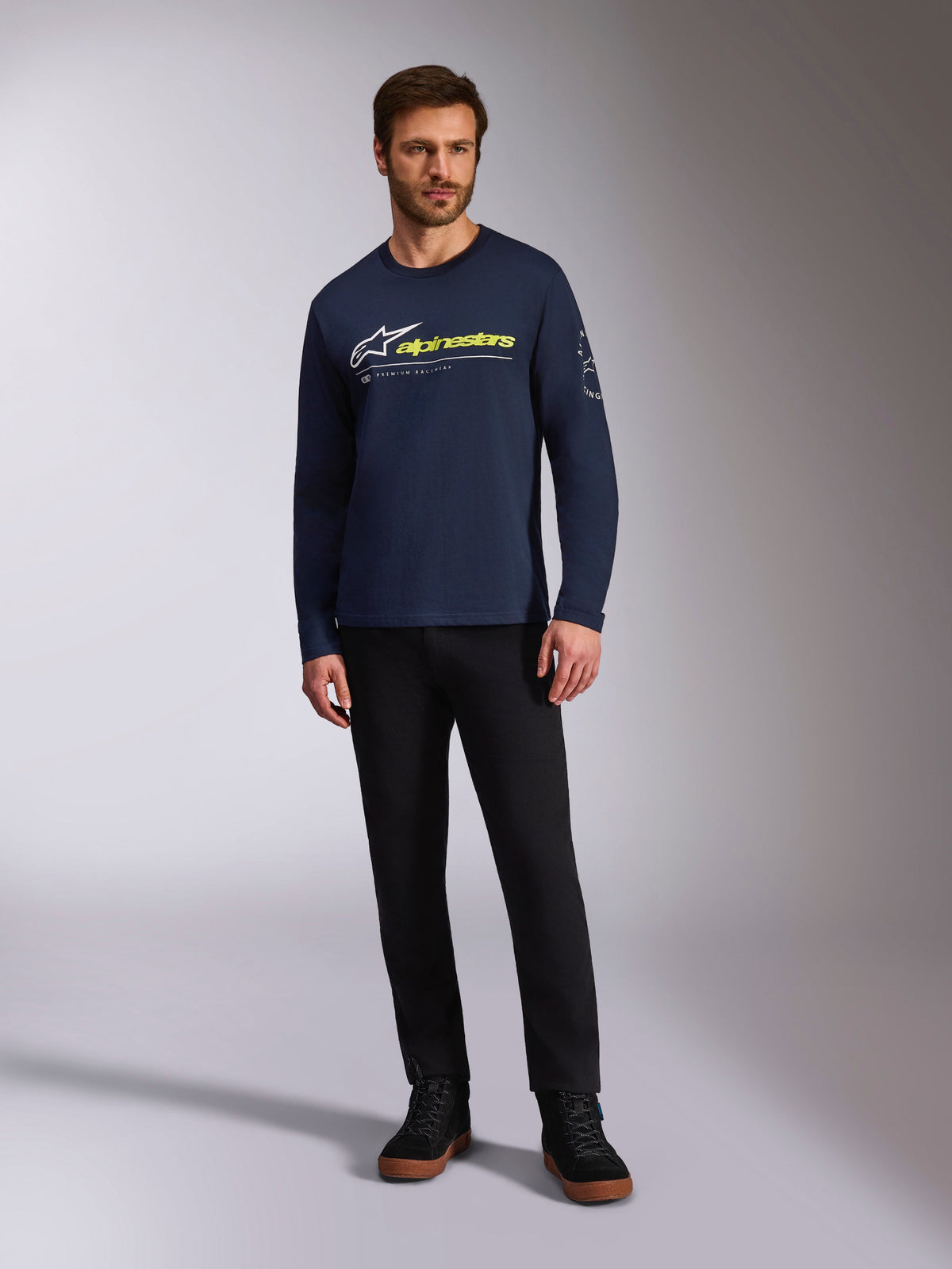 Alpinestars Mandatory CSF Tee, maglietta a maniche lunghe, blu navy, logo Astars bianco con logo testuale giallo neon, indossata da un modello con pantaloni neri e sneakers nere, streetwear casual da motorsport
