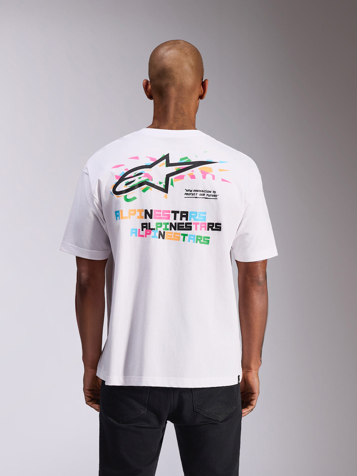 Alpinestars Wild Oversized CSF Tee, t-shirt a maniche corte, bianca, vista posteriore con vivace logo Astars multicolore e stampe di testo, vestibilità oversize, streetwear casual motorsport