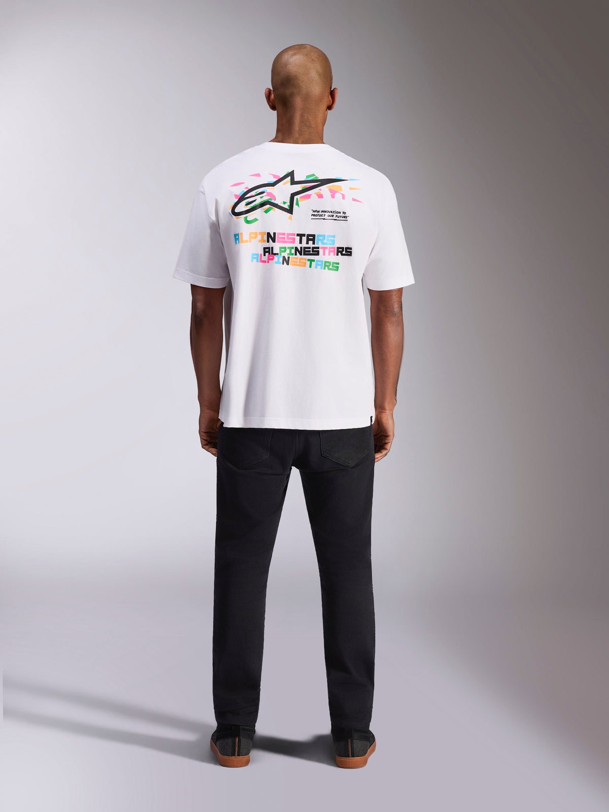 Alpinestars Wild Oversized CSF Tee, maglietta a maniche corte, bianca, vista posteriore con vivace logo Astars multicolore e tipografia ripetuta, streetwear casual ispirato al motorsport