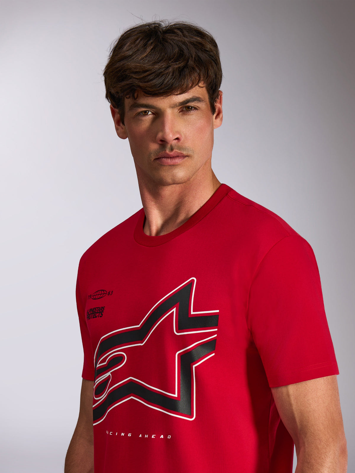 Alpinestars Authority CSF Tee, t-shirt a maniche corte, rosso, grande logo Astars ritagliato nero e bianco con contorno, indossata da un modello, streetwear casual ispirato al motorsport