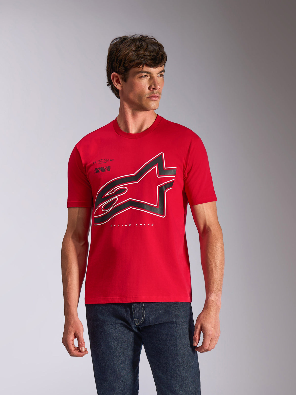 Alpinestars Authority CSF Tee, t-shirt a maniche corte, rosso, grande logo Astars con contorno nero e bianco sul petto, indossata da un modello maschile con jeans blu scuro, streetwear casual ispirato al motorsport