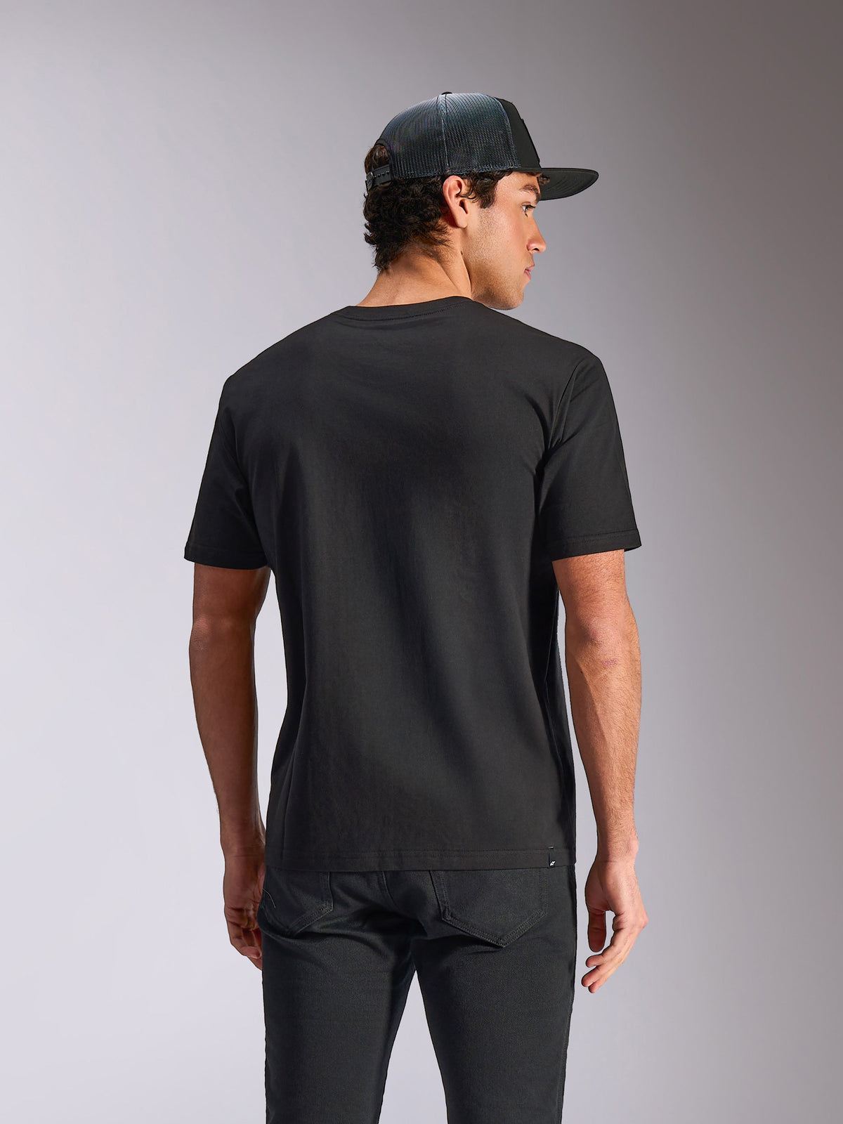 Alpinestars Verdure Camo CSF Tee, t-shirt a maniche corte, nera, vista posteriore, indossata con un cappellino mesh e pantaloni neri, streetwear casual motorsport