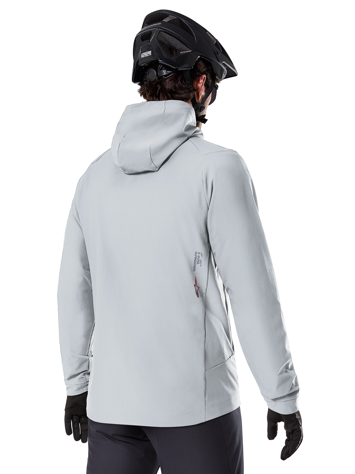 Giacca Termica Alpinestars A-Dura, Grigio Titanio, vista posteriore di un rider che indossa la giacca isolata con cappuccio, abbinata a un casco MTB nero e guanti neri, con un piccolo logo Alpinestars sulla parte inferiore della schiena, progettata per mountain bike in condizioni di freddo
