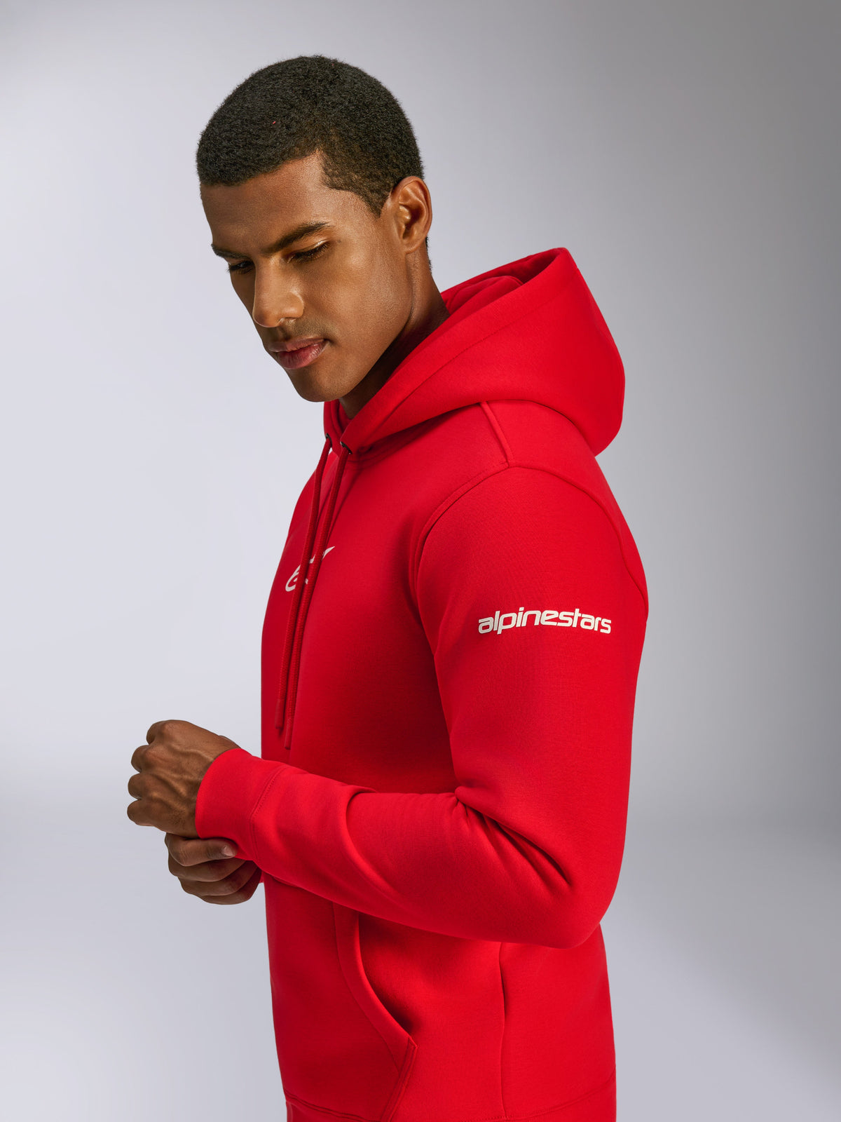 Alpinestars Felpa con cappuccio Frontal, rosso, felpa in pile pull-over indossata da un modello, con scritta Alpinestars bianca sulla manica, logo frontale, tasca a marsupio e cappuccio con cordino, design casual ispirato al motorsport