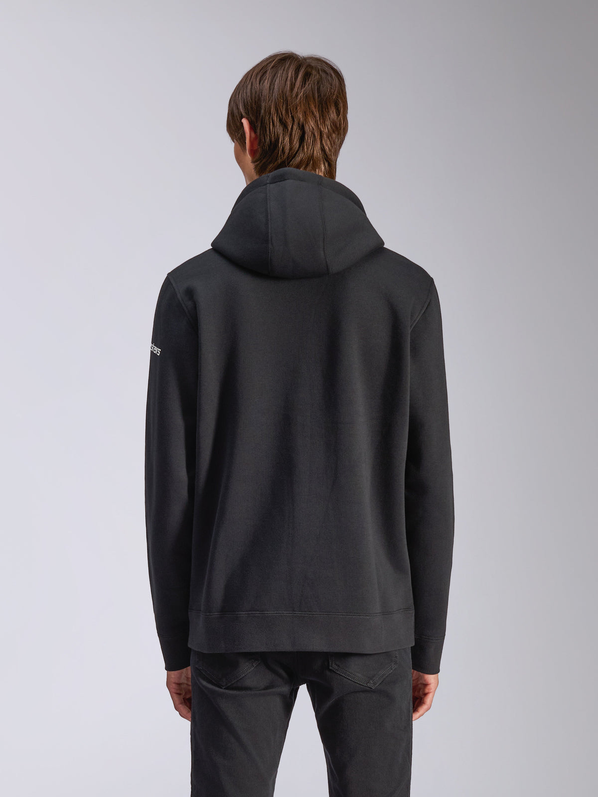 Alpinestars Felpa con cappuccio Frontal, nero, vista posteriore di una felpa casual, con cappuccio foderato, orlo a coste e logo bianco sulla manica, abbigliamento streetwear ispirato al motorsport