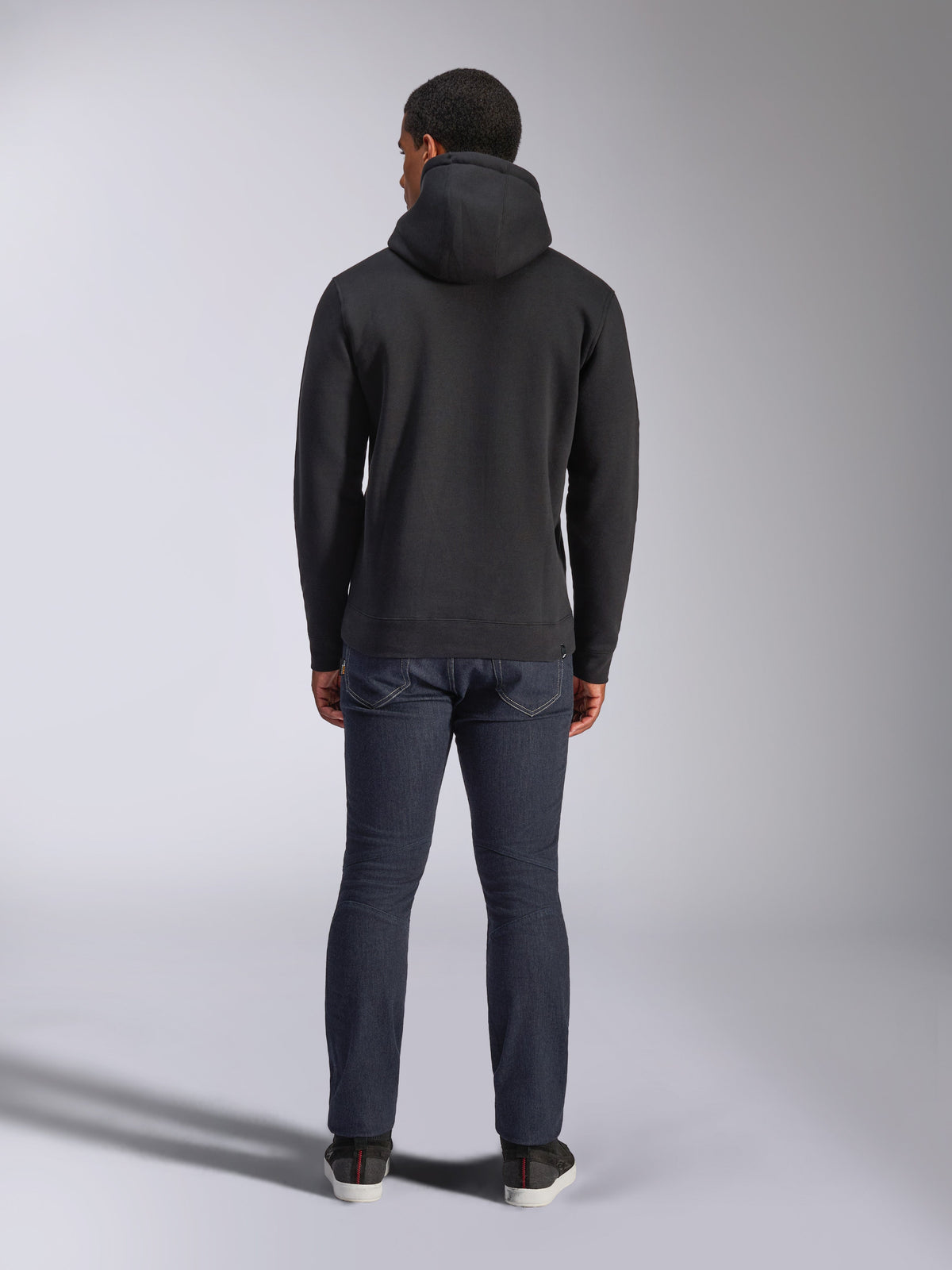 Alpinestars Blaze V3 Hoodie, streetwear casual, nero, vista posteriore di felpa in pile con cappuccio, indossata con jeans in denim blu scuro e scarpe nere, design pulito ispirato al motorsport