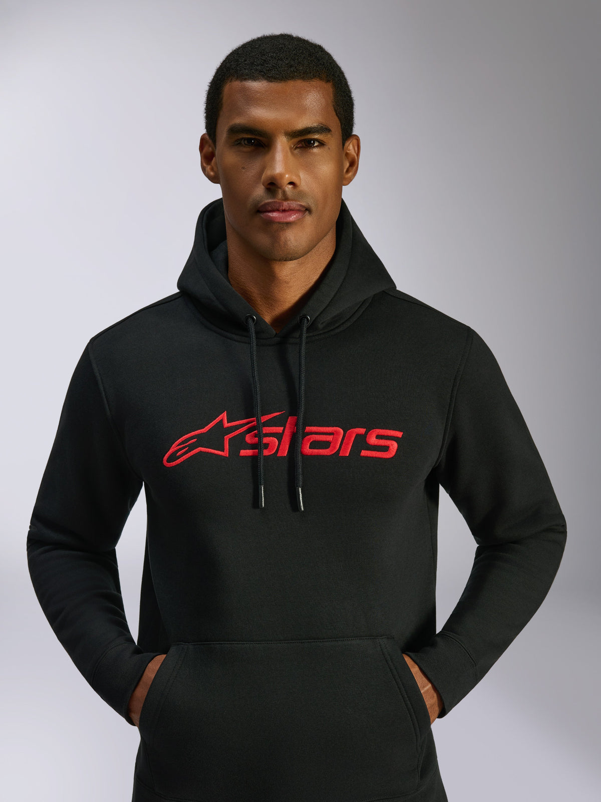 Felpa con cappuccio Alpinestars Blaze V3, streetwear casual, nera con logo Alpinestars rosso sul petto, indossata da un uomo, cappuccio con coulisse, maniche lunghe, design moderno ispirato al motorsport