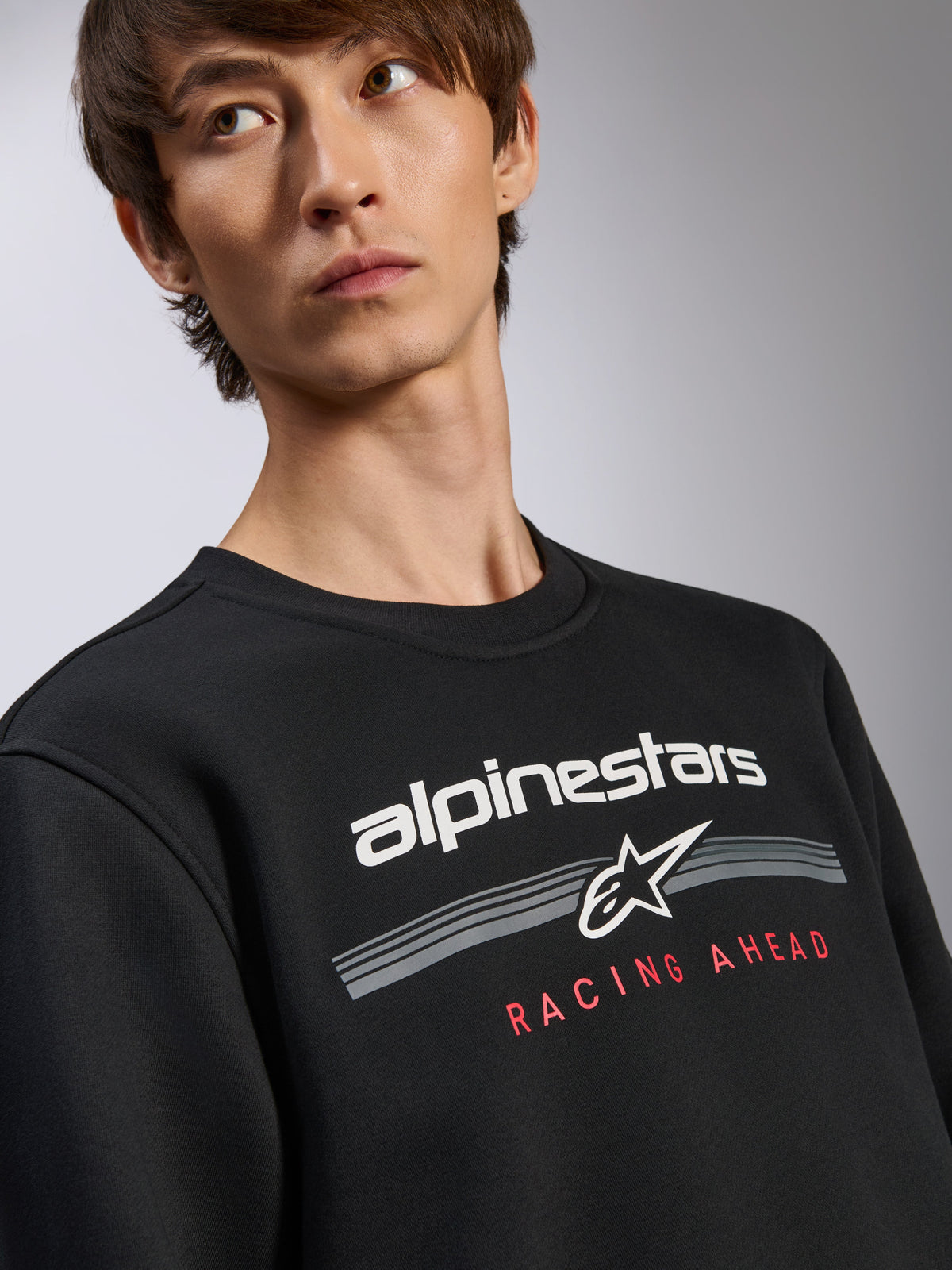 Alpinestars Bettern Crew Pullover, felpa nera, logo Alpinestars bianco con grafica rossa 'Racing Ahead', girocollo, streetwear casual ispirato al motorsport