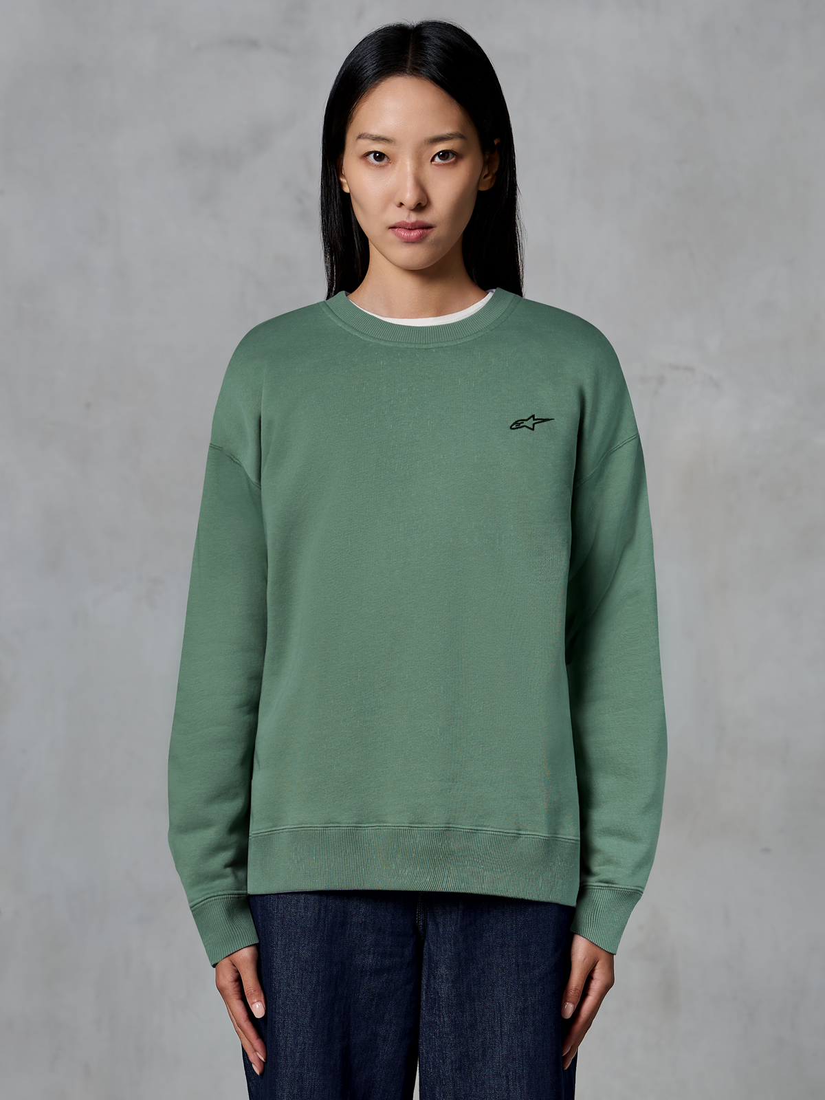 Alpinestars Essentials Ageless Crew, felpa girocollo, verde cactus, indossata da una modella, piccolo logo nero sul petto, colletto, polsini e fondo a costine, streetwear casual motorsport