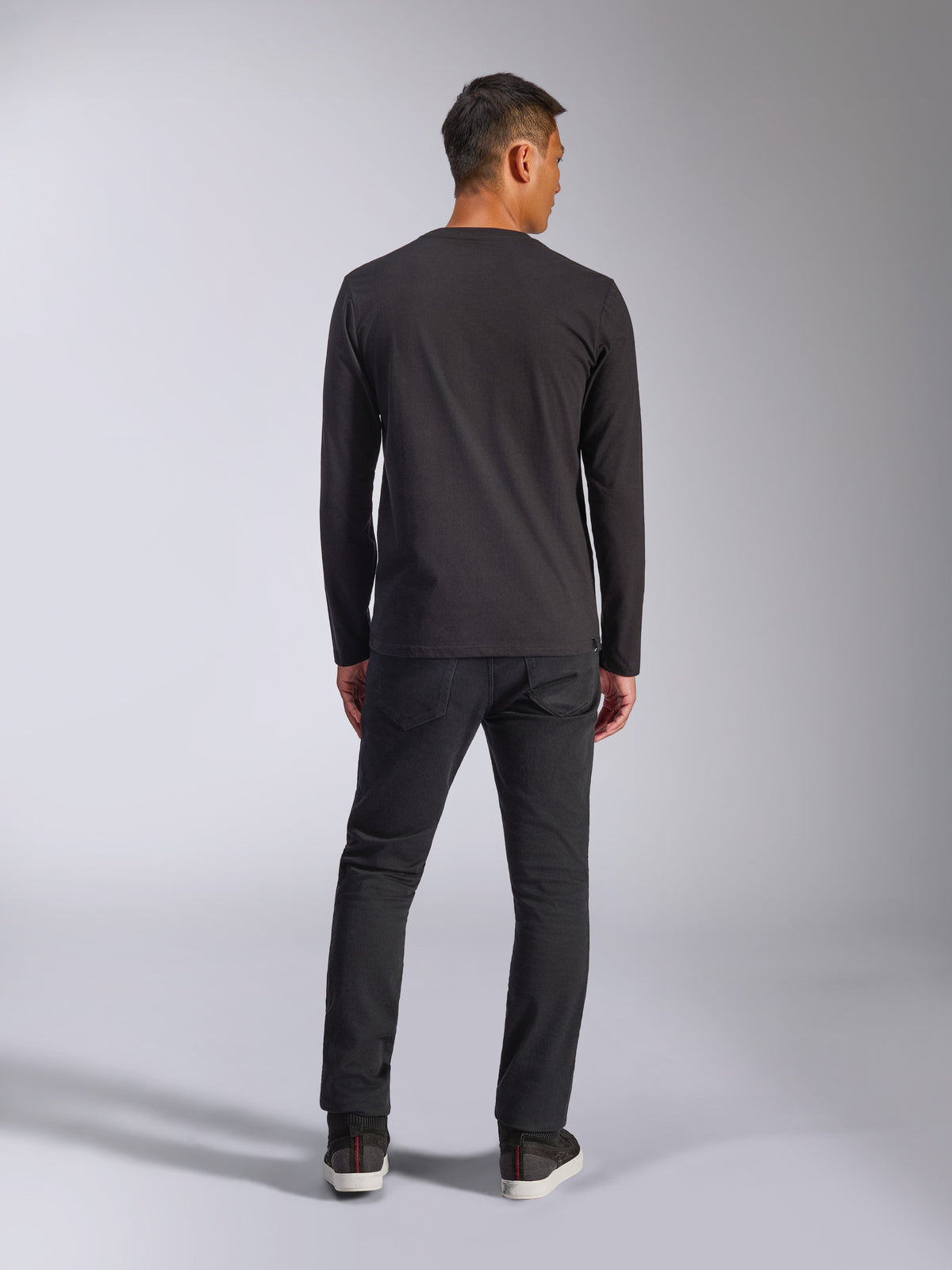 Alpinestars Trackside CSF Tee, maglia a maniche lunghe, nero, vista posteriore del modello che indossa la maglia con pantaloni scuri, streetwear casual ispirato al motorsport