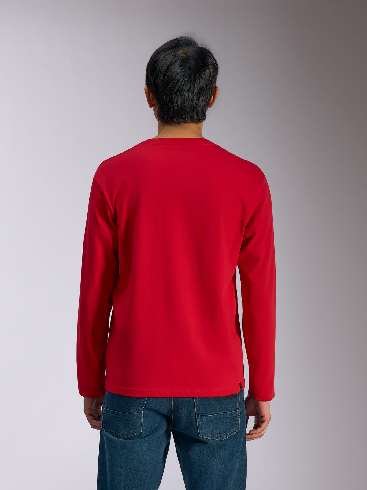 Alpinestars Trackside CSF Tee, maglietta a maniche lunghe, rosso, vista posteriore, indossata da un modello con jeans blu, abbigliamento sportivo casual ispirato al motorsport