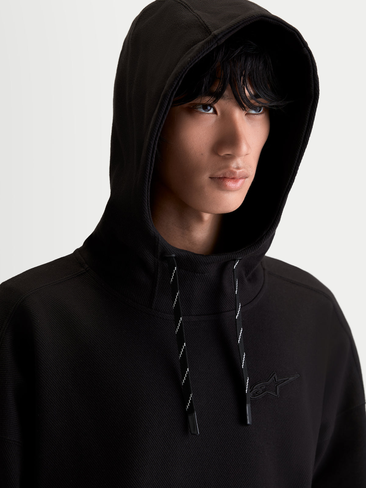 Alpinestars Felpa con cappuccio Camino Textured Oversize, felpa sportswear nera, tessuto in pile di twill lavorato a maglia testurizzato, collo alto e cappuccio, logo Astars ricamato sul petto, vestibilità oversize rilassata per uno stile lifestyle motorsport
