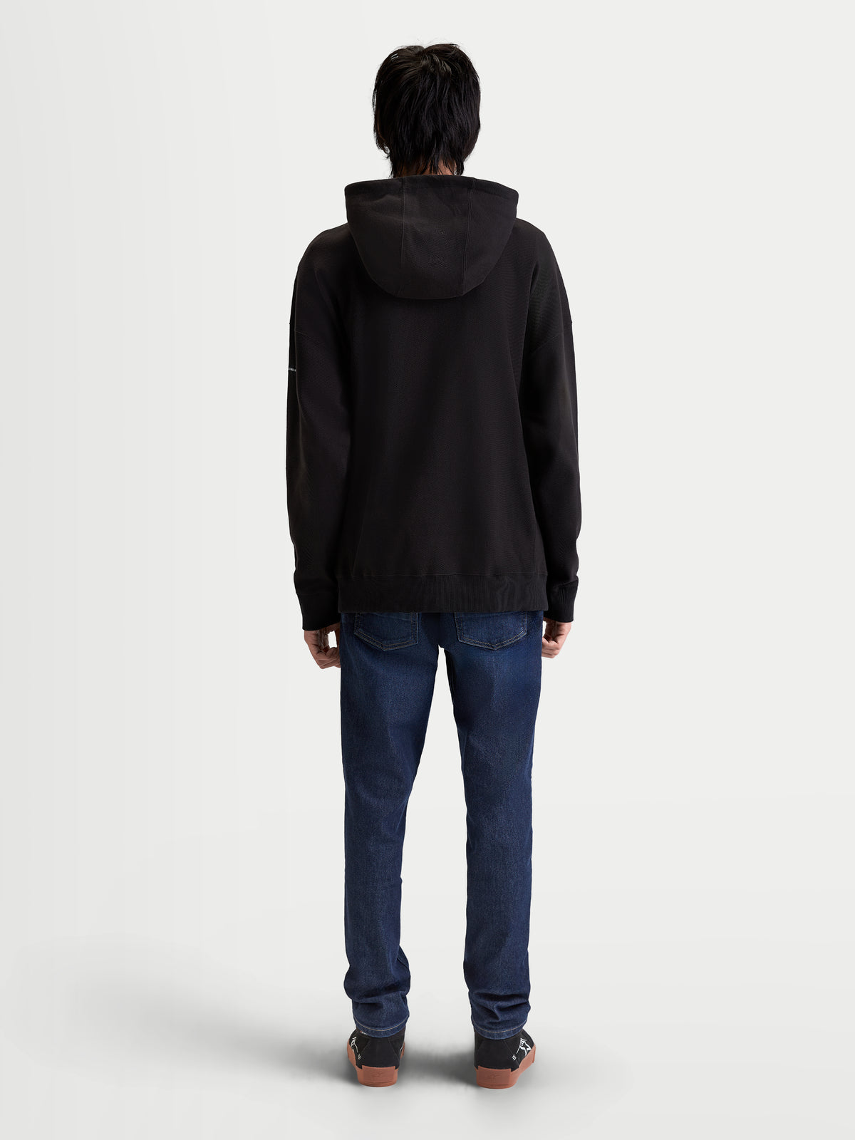 Alpinestars Felpa con cappuccio Camino Textured Oversize, felpa sportswear premium nera, vista posteriore su modello, vestibilità rilassata in pile di twill lavorato a maglia testurizzato