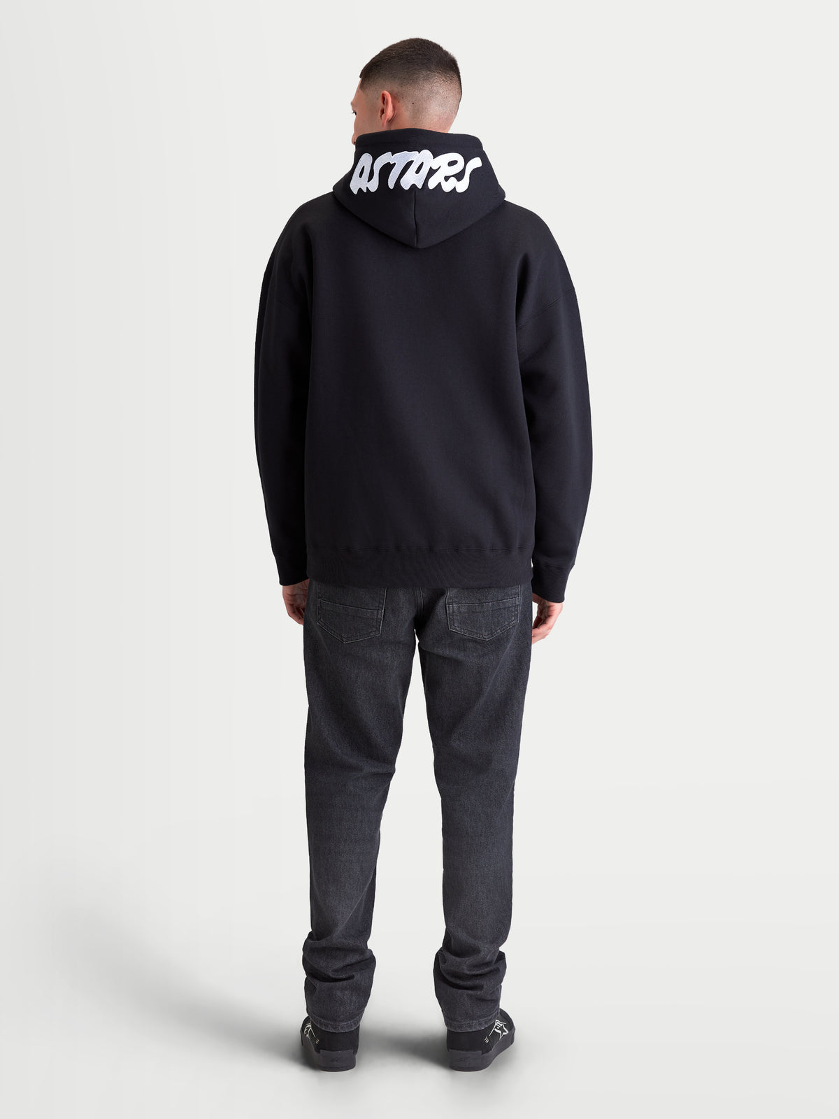 Alpinestars Felpa con cappuccio Pioneer Oversized, vista posteriore con ricamo bianco Astars sul cappuccio, vestibilità oversize, nera, in misto cotone per sportswear casual.
