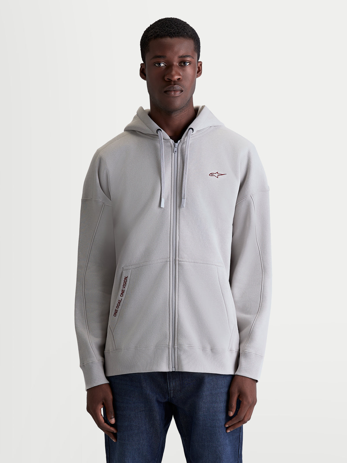 Alpinestars Felpa con cappuccio Pioneer Oversize, felpa sportswear unisex grigio cemento, vestibilità ampia con cerniera Vislon, tasca a marsupio con ricamo One Goal One Vision e cappuccio foderato, stile casual.