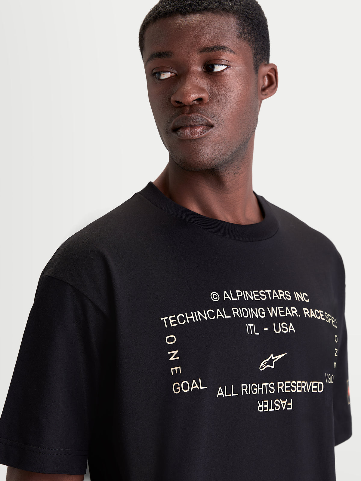 Alpinestars maglietta Infinity Oversized CSF, maglietta a maniche corte nera, dettaglio della grafica tecnica motorsport bianca sul petto, vestibilità oversized, in misto cotone e poliestere, stile sportswear casual off-bike.