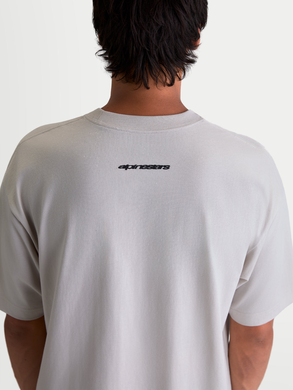 Alpinestars Maglietta Mandate Oversized CSF, maglietta a maniche corte da uomo, grigio cemento, con logo Alpinestars nero sulla parte superiore della schiena, vestibilità oversized, stile sportswear casual.