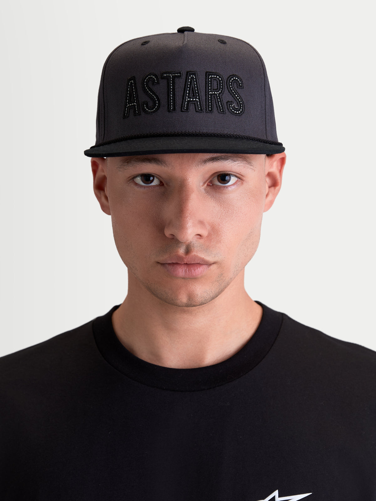 Alpinestars Stadium Snapback, cappello lifestyle sportswear da uomo, grigio scuro e nero, corona strutturata con applicazione frontale del logo ASTARS e visiera piatta, indossato da un modello