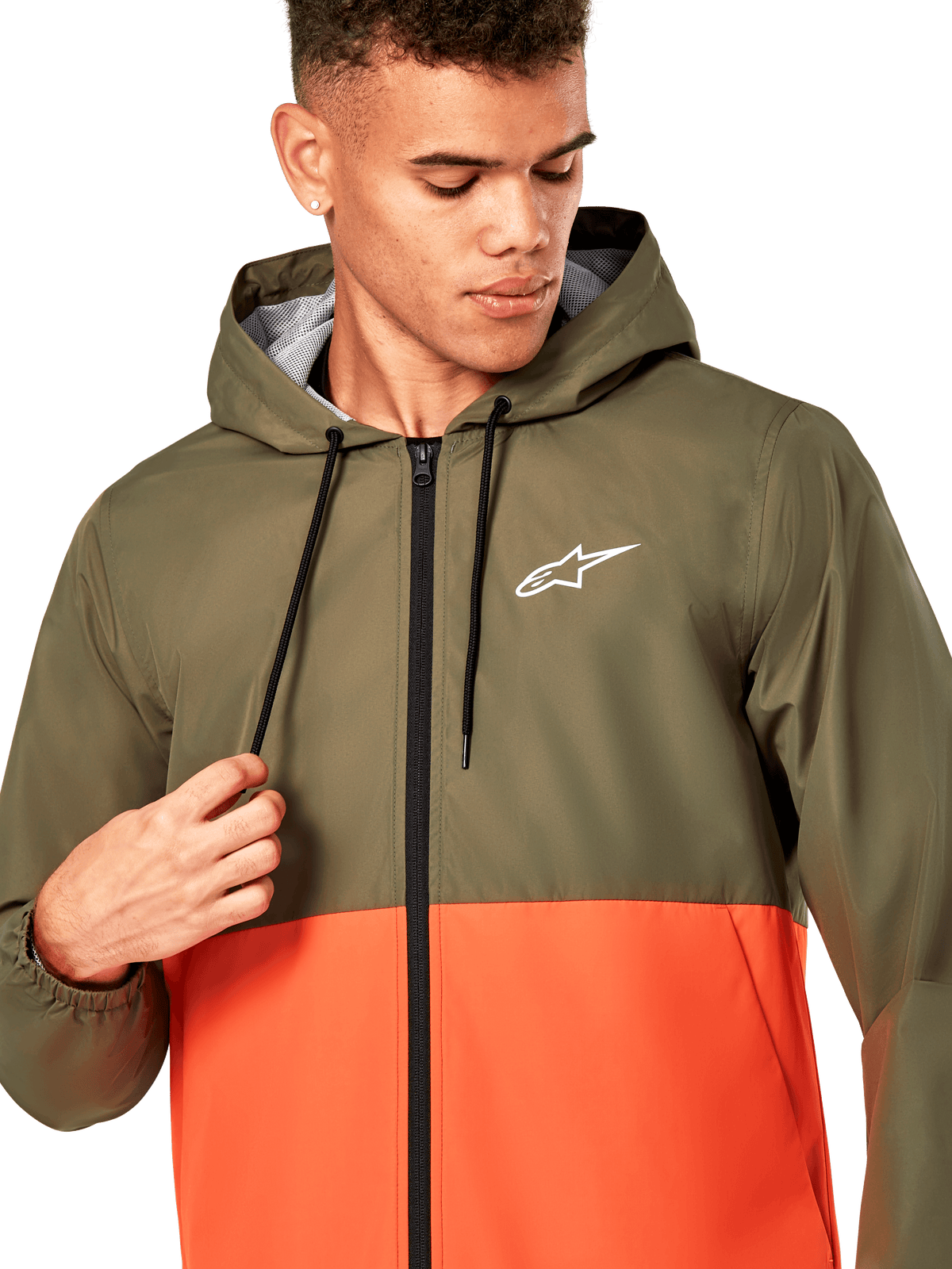 Alpinestars Speeder Windbreaker Jacket, giacca a vento leggera con cappuccio, design colorblock verde oliva e arancione militare, logo Alpinestars bianco sul petto, cerniera e cordoncini neri, abbigliamento sportivo casual ispirato al motorsport