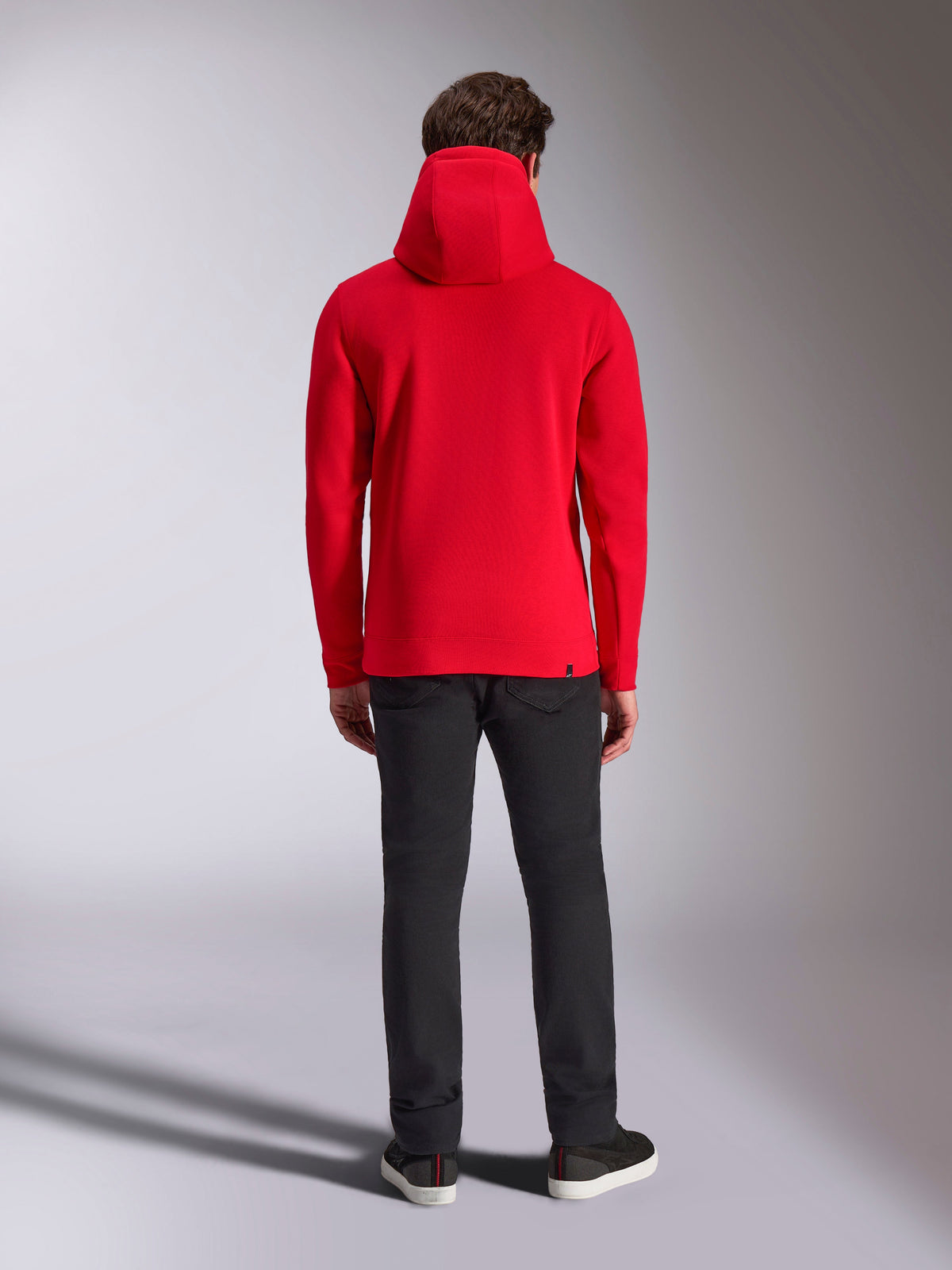 Alpinestars Ride V3 Hoodie, vista posteriore, rosso tinta unita, felpa casual in pile ispirata al motorsport, cappuccio foderato in jersey, polsini e bordo a coste, abbinata a pantaloni neri e sneakers