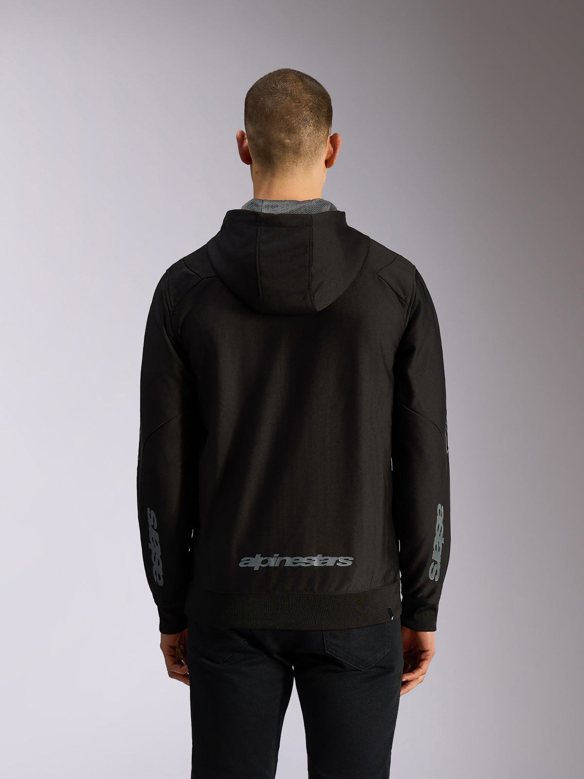 Alpinestars Sessions V3 Hoodie, vista posteriore, felpa nera con cappuccio e zip con scritta Alpinestars grigia sulla parte inferiore della schiena, logo Astars sulle maniche, orlo e polsini a coste, streetwear casual a tema motorsport