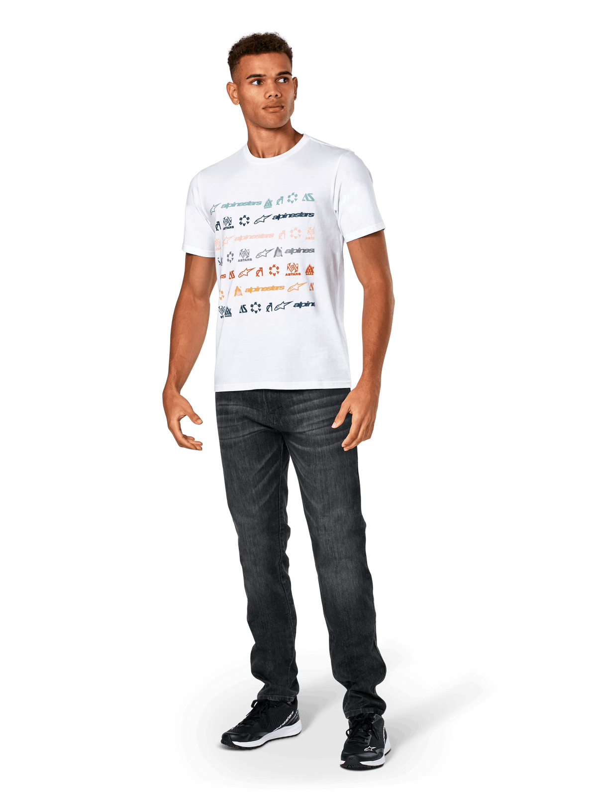 T-shirt Alpinestars Glyfs CSF, maglietta a maniche corte, bianca, con grafica a righe multi-logo sul davanti, indossata con jeans grigio scuro e sneakers nere, abbigliamento sportivo casual ispirato al motorsport