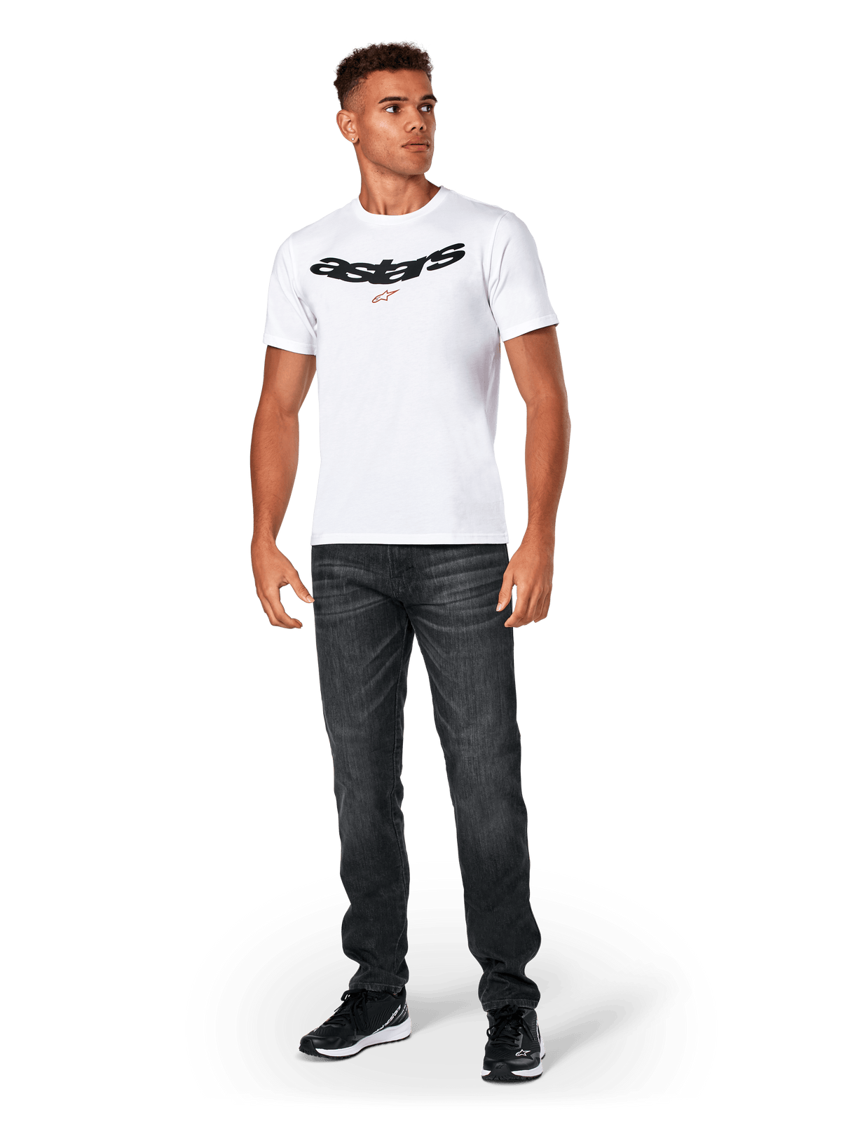 Alpinestars Elliptic CSF Tee, maglietta a maniche corte, bianca, logo Astars arcuato nero con simbolo della stella arancione, indossata da un modello con jeans neri e sneakers, streetwear casual motorsport