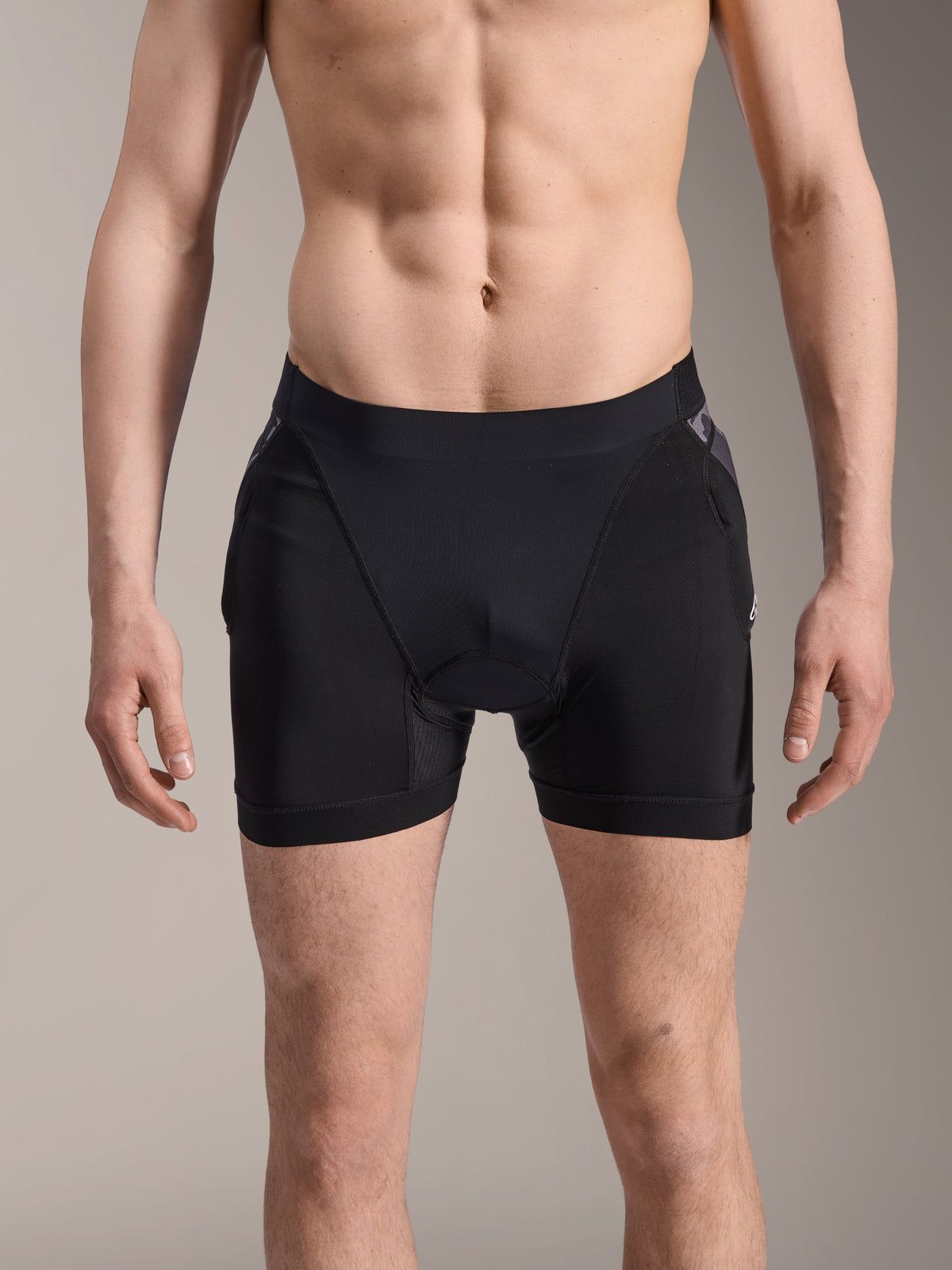 Alpinestars A-Motion Plasma Protection Boxers, pantaloncini protettivi MTB, neri con dettagli Black Camo, vista frontale su modello maschile, in rete elastica traspirante e protezione integrata per i fianchi per prestazioni ciclistiche.