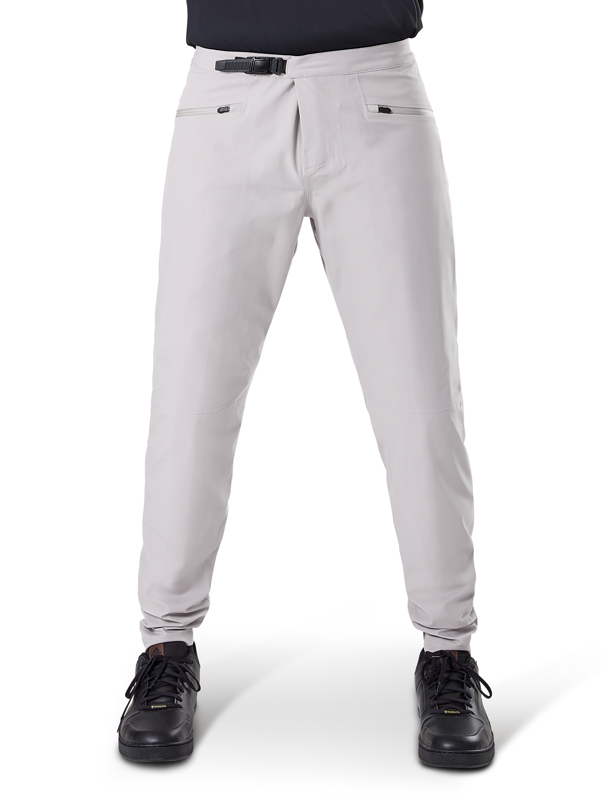 Pantaloni impermeabili Alpinestars A-Dura, pantaloni da ciclismo MTB, grigio titanio, vista frontale, con chiusura a cricchetto nera in vita e due tasche con cerniera, polsini elasticizzati, indossati con sneakers nere, abbigliamento tecnico impermeabile per mountain bike