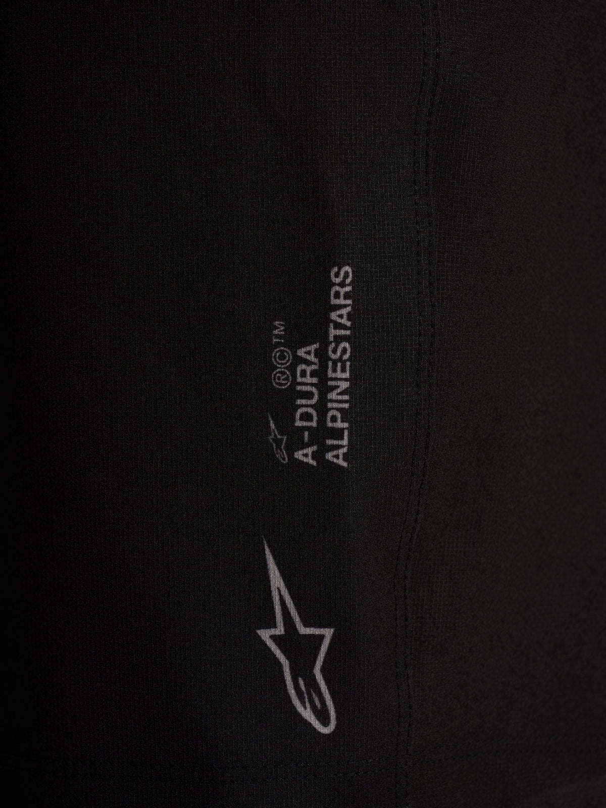 Dettaglio pantaloncini Alpinestars A-Dura Ride neri, tessuto tecnico elasticizzato a 4 vie con loghi bianchi.