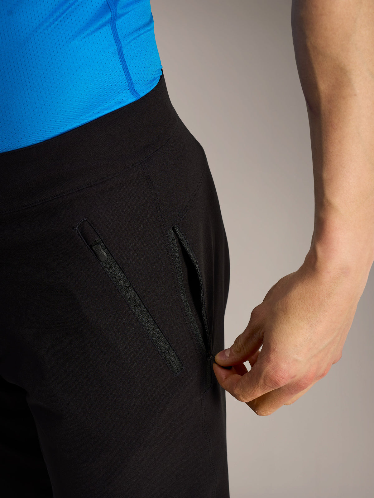 Pantaloncini MTB Alpinestars A-Dura Ride neri, primo piano di una mano che apre una tasca laterale con zip.