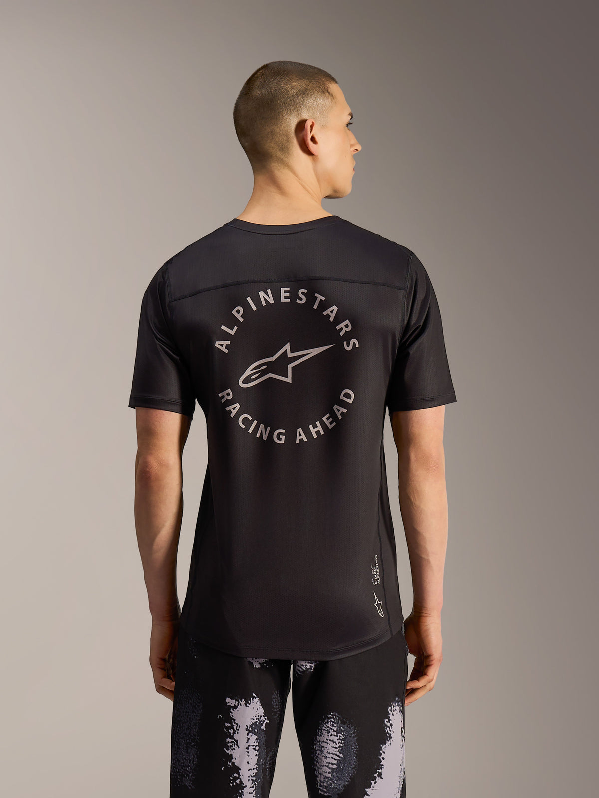 Alpinestars A-Dura Ride Shorts Black Camo e maglia MTB nera con logo circolare sul retro, vista posteriore.