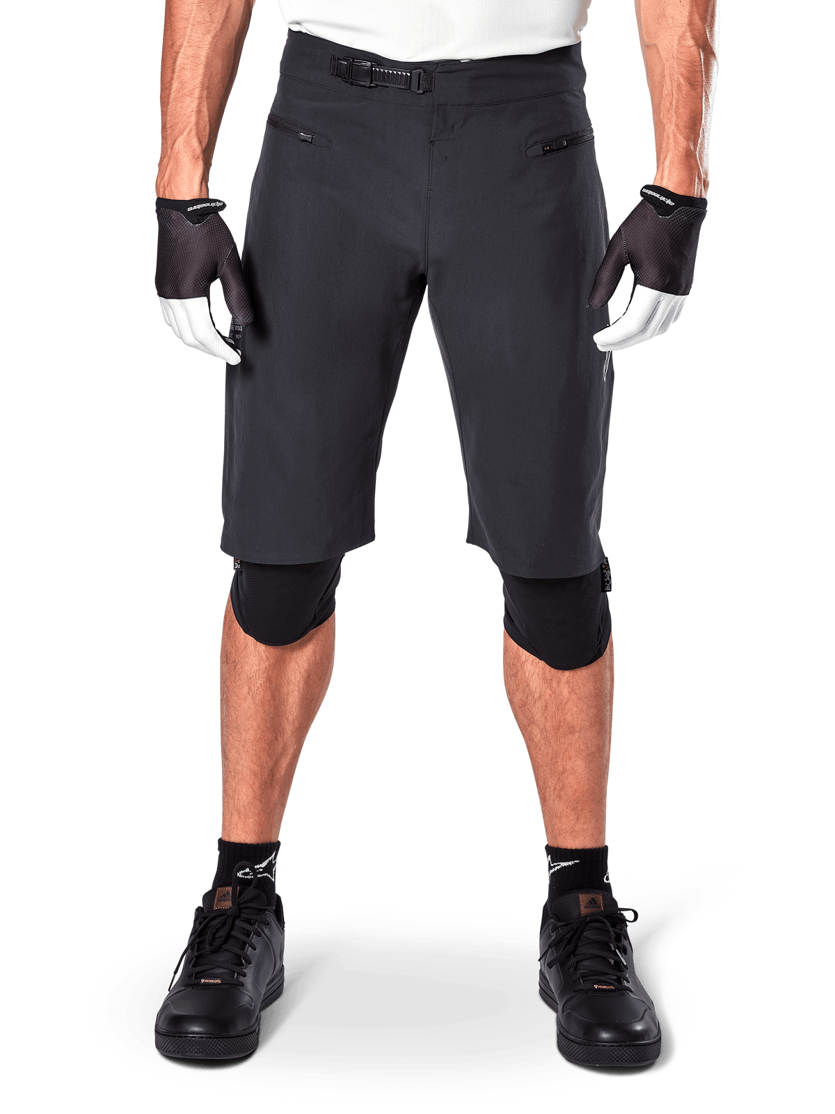 Pantaloncini Alpinestars A-Aria, pantaloncini da mountain bike neri, con chiusura a cricchetto in vita e tasche con cerniera, indossati con guanti bianchi e neri e ginocchiere, abbigliamento tecnico da ciclismo per il fuoristrada