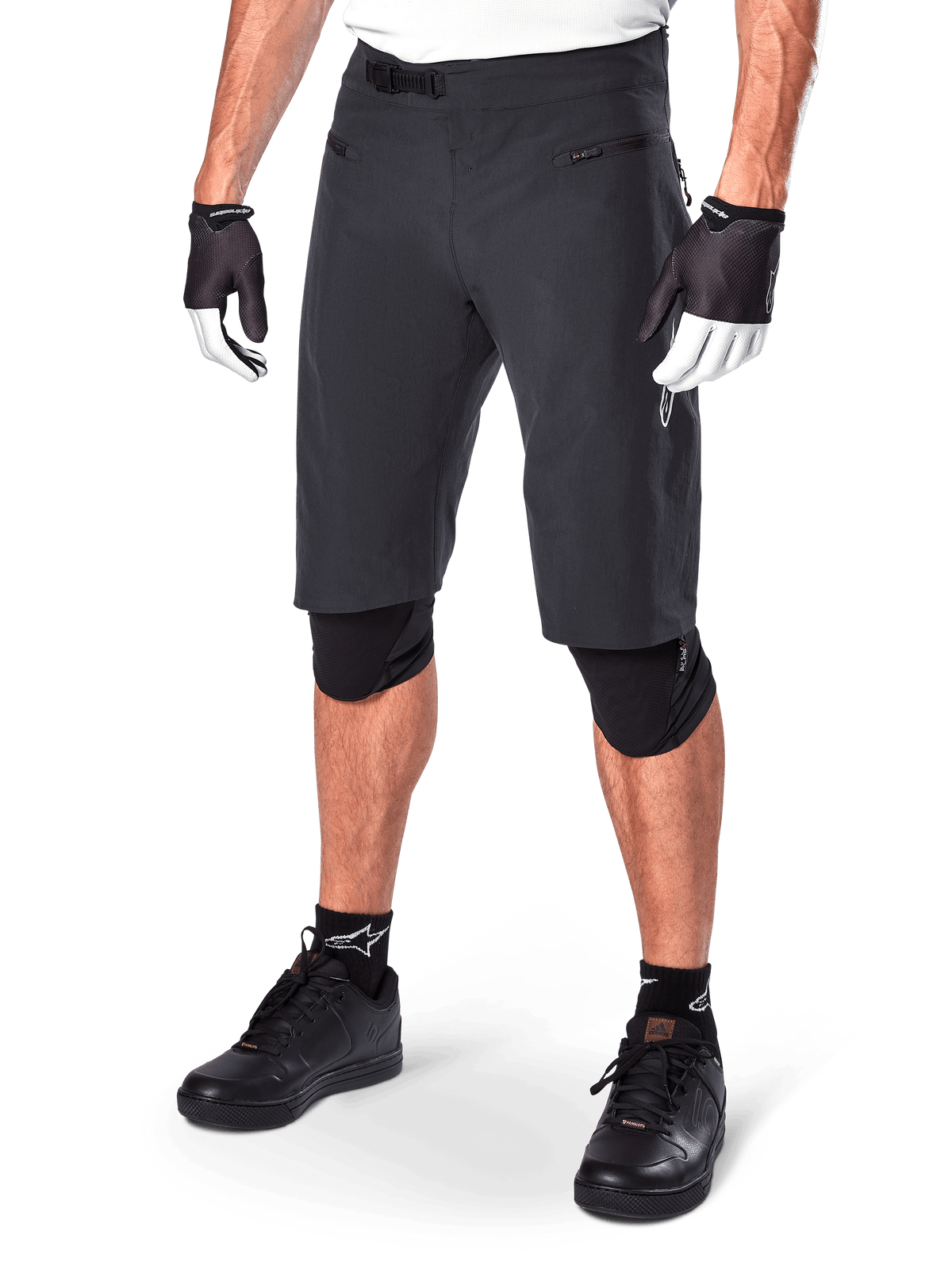Alpinestars A-Aria Shorts, pantaloncini da mountain bike, neri, lunghezza al ginocchio con tasche anteriori con zip e fibbia a cricchetto regolabile in vita, indossati con ginocchiere nere, calze e guanti da ciclismo